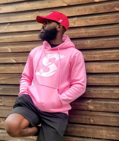 A man wearing a baby pink activewear gym hoodie with a white 'S' logo on the front. 